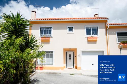 a white house with a blue sign in front of it at Villa 6pax baby friendly Near Dino Park&Beaches in São Bartolomeu