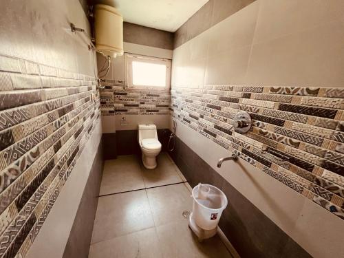 a bathroom with a toilet and a window at Mountain View Resort - A Hidden Resort Manali in Manāli