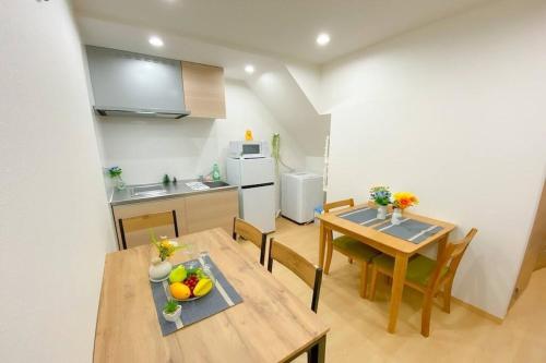 cocina y comedor con mesa y sillas en Guest House HARU DREAM ABENO HOUSE, en Osaka