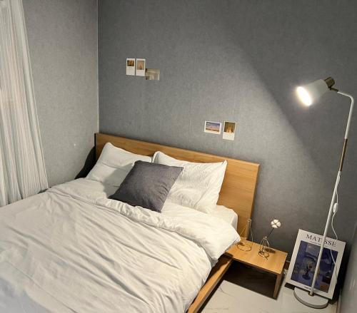 una camera con letto e tavolo con lampada di Masil a Seul