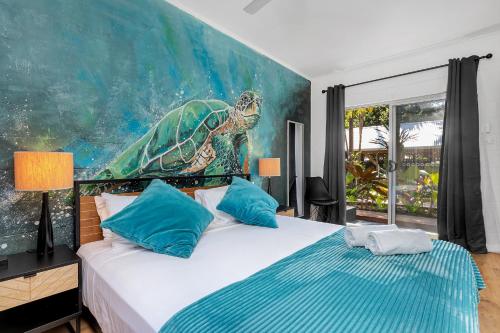 a bedroom with a turtle painting on the wall at The Palms At Palm Cove in Palm Cove