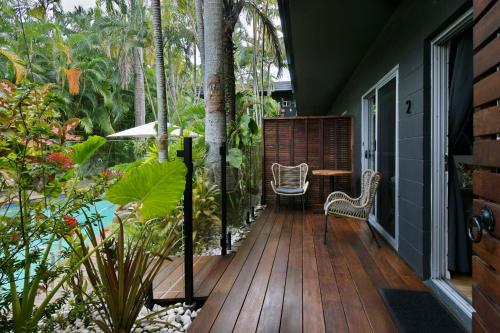 an outdoor deck with a table and chairs on a house at The Palms At Palm Cove in Palm Cove