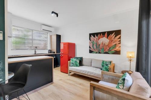 a living room with a couch and a red refrigerator at The Palms At Palm Cove in Palm Cove