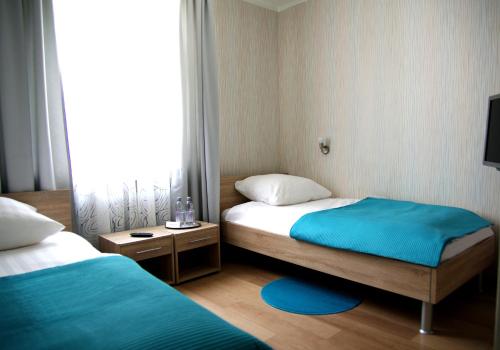 a small room with two beds and a window at Waldhotel Bad Münstereifel in Bad Münstereifel