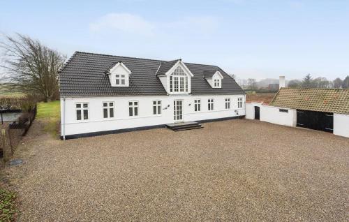 a large white building with a black roof at Nice Home In Roslev With Kitchen in Roslev