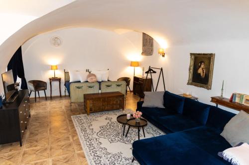 a living room with a blue couch and a table at Opera apartments in Banská Štiavnica