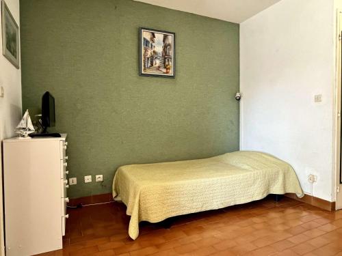 une chambre avec un lit et un mur végétal dans l'établissement Studio à Argelès-sur-Mer, 400m de la plage et proche commerces, loggia, animaux bienvenus, ménage inclus - FR-1-225-548, à Argelès-sur-Mer