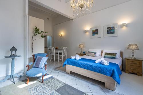 ein Schlafzimmer mit einem blauen Bett und einem Stuhl in der Unterkunft Cozy Carisma Lodging - Central, New and Independent Studio Apartment in Sliema