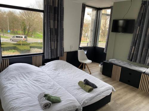 a bedroom with a bed and a large window at Hotel Cafe The Windmill in Schiedam