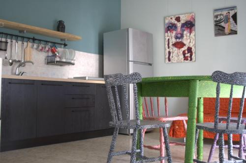 una cucina con 2 sedie, un tavolo e un frigorifero di La casetta a San Marco Evangelista