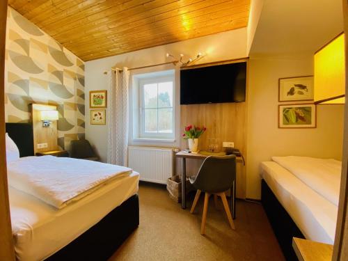 ein Hotelzimmer mit 2 Betten und einem Schreibtisch in der Unterkunft Hotel Zur Kutsche in Oberschöna
