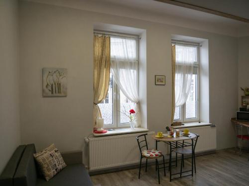 - un salon avec une table et 2 fenêtres dans l'établissement Apartament przy synagodze, à Przemyśl