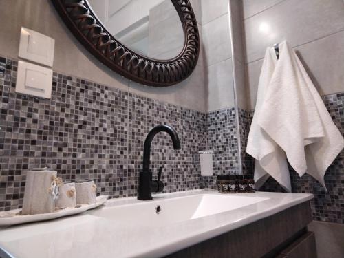 a bathroom with a sink and a mirror at Litsa's House Platanias in Agia Paraskevi