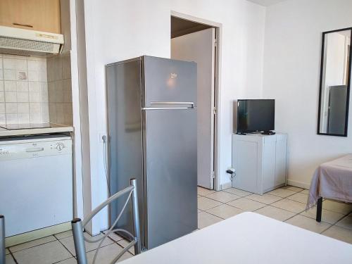 Il comprend une cuisine équipée d'un réfrigérateur en acier inoxydable et une télévision. dans l'établissement Résidence Graziella Studio 624, à Juan-les-Pins
