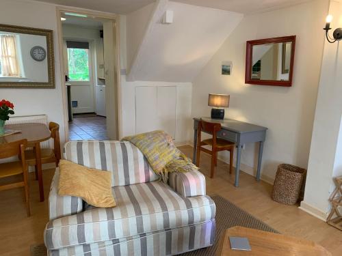 a living room with a couch and a table at Bell Cottage in Bridport