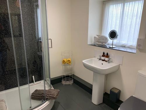 a bathroom with a sink and a shower at Bell Cottage in Bridport