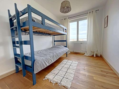 - une chambre avec un lit superposé bleu et un tapis dans l'établissement Superbe T3 proche plage avec loggia, Wifi, bien décoré - FR-1-646-45, à Berck-sur-Mer