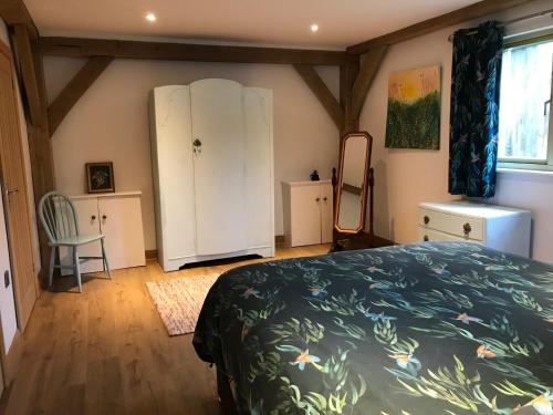 a bedroom with a bed and a dresser and a mirror at Oak Lodge in Tavistock