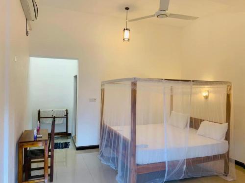 a bedroom with a bed with a mosquito net at Hari Hari Arugambay in Arugam Bay