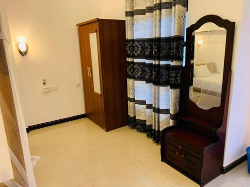 a room with a mirror and a dresser and a door at Hari Hari Arugambay in Arugam Bay