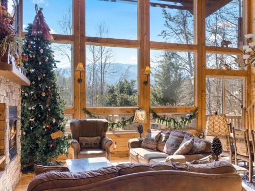 a living room with a christmas tree and a large window at Rainbows End in Gatlinburg