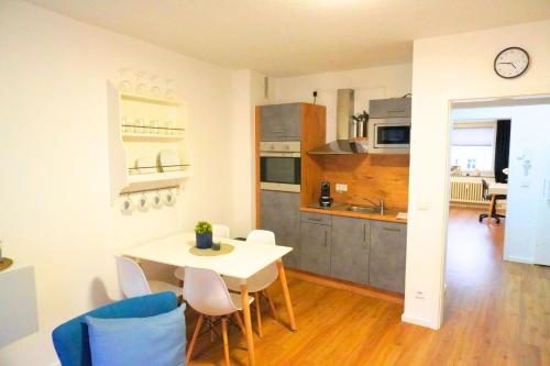 a kitchen and dining room with a white table and chairs at Living-Life, Klinik & Messe vor Ort, Wlan, Netflix in Essen