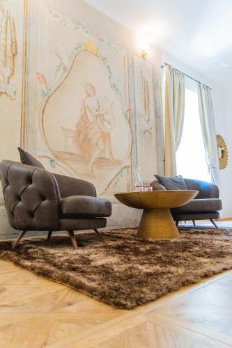 two chairs and a table in a living room at Opera apartments in Banská Štiavnica