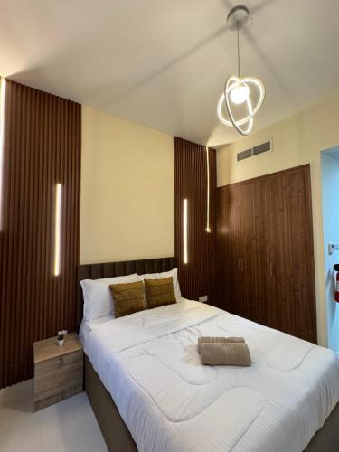 a bedroom with a large white bed and a chandelier at RksHome Studio Apartment Baniyas Metro Exit 2 in Dubai