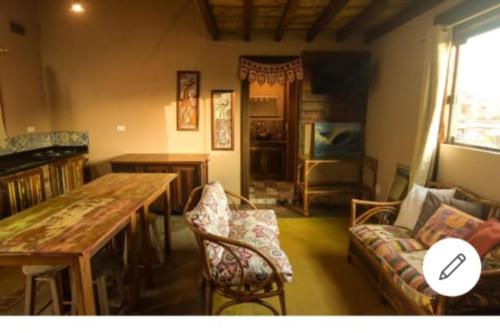 a living room with a wooden table and a couch at Residencial Banzaê in Garopaba