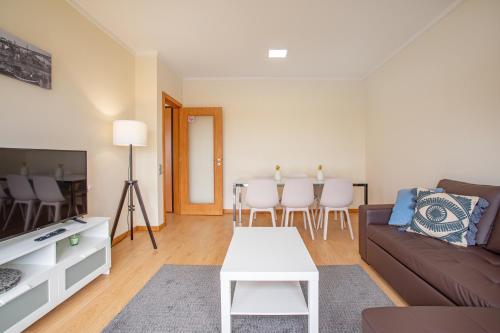 ein Wohnzimmer mit Sofa und Tisch in der Unterkunft Gaia Panoramic Terrace Apartment - D. Pedro V in Vila Nova de Gaia