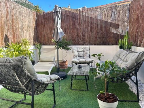 un patio con 2 sillas, una mesa y algunas plantas en Monaco Cap d’ail Studio & jardin en Cap d'Ail