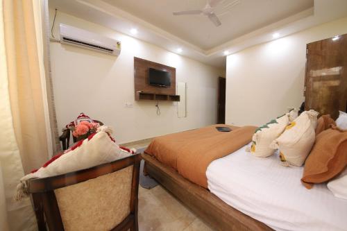 a bedroom with two beds and a tv on the wall at Perfectstayz Value Hills near Laxman Jhula in Rishīkesh