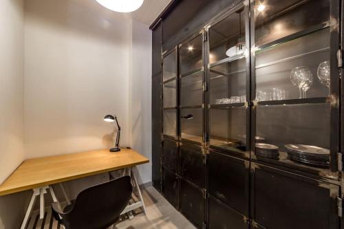 een zwarte kast met een tafel in een keuken bij Superbe studio style industriel à Charbonnière in Charbonnières-les-Bains