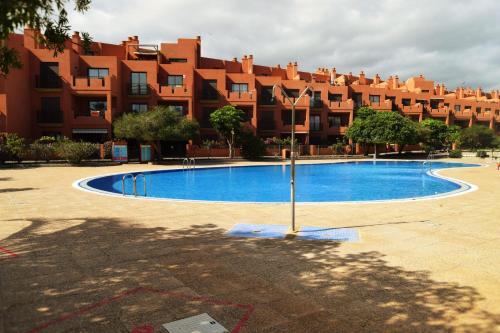 een zwembad voor een groot gebouw bij Paraiso La Tejita, preciosa terraza y playa in La Tejita
