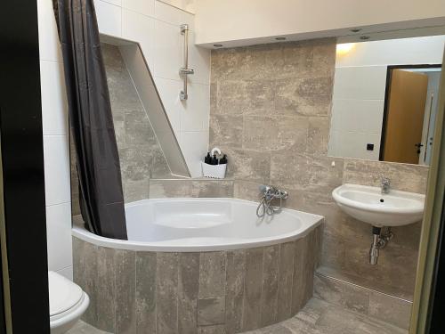 Un baño con bañera, lavabo e inodoro. en Focky City Apartments, en Viena