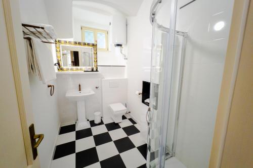 a bathroom with a black and white checkered floor at Opera apartments in Banská Štiavnica