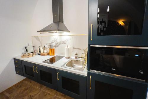 a kitchen with a sink and a microwave at Opera apartments in Banská Štiavnica