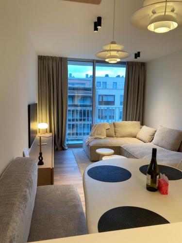 a living room with a couch and a table at Luxe appartement `t Sant Nieuwpoort Bad in Nieuwpoort
