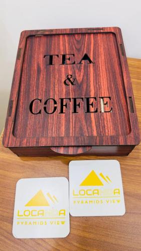 a wooden coffee box with two cards on a table at Locanda pyramids view in Cairo