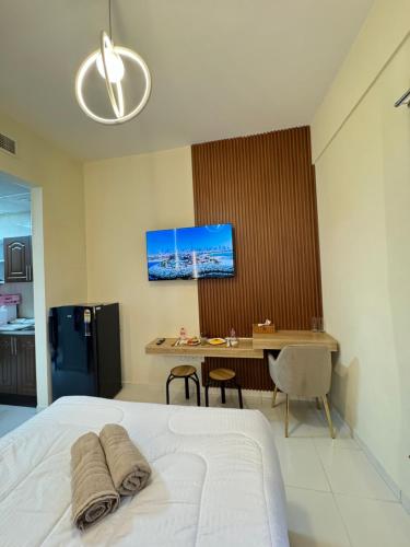 a bedroom with a bed and a desk with a computer at RksHome Studio Apartment Baniyas Metro Exit 2 in Dubai
