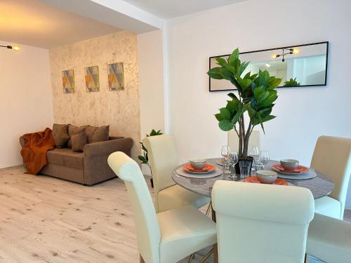 a dining room and living room with a table and chairs at Luxury Glam Apartments Sibiu near Station and Mall in Sibiu