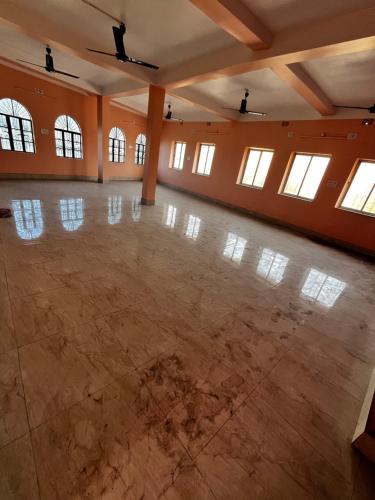 een grote lege kamer met een grote dansvloer bij RATNA NIBAS 