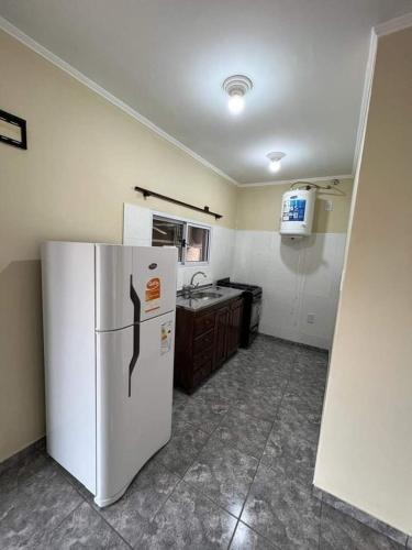 a kitchen with a white refrigerator and a sink at Don machado in Puerto Iguazú