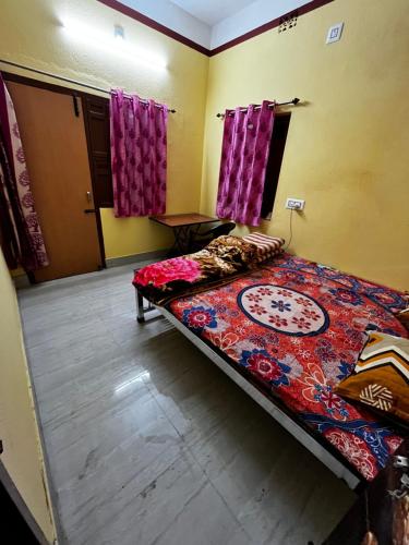 een slaapkamer met een bed in een kamer met paarse gordijnen bij RATNA NIBAS 