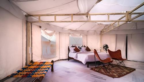 - une chambre avec un lit dans une tente dans l'établissement Jaisalmer Royal Desert Safari Camp, à Sām