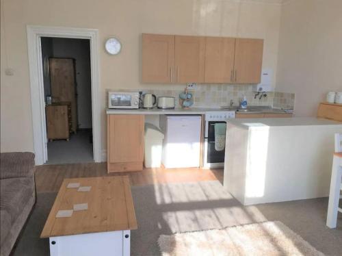 a kitchen with a couch and a table in a room at Spacious 1 Bedroom Apartment near Seafront in Penzance