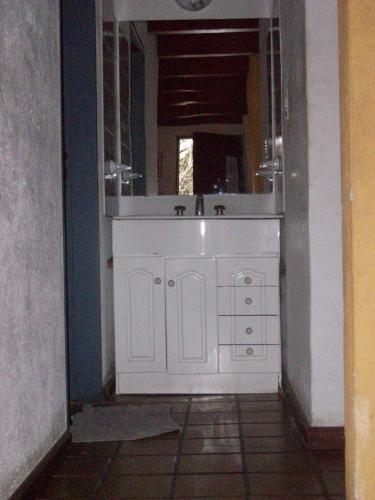 a bathroom with a white sink and a mirror at Cabañas El Paraiso in San Marcos Sierras