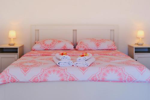 un letto con lenzuola e cuscini rosa e bianchi di Country House a Čunski