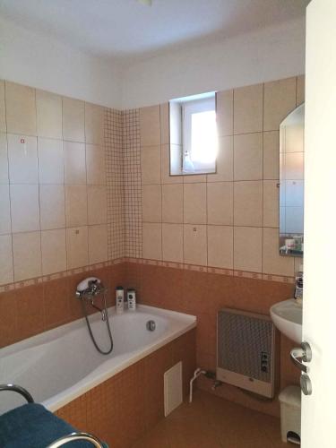 a bathroom with a bath tub and a sink at Studio in Csopak - Balaton 48108 in Csopak