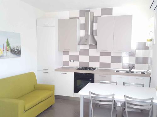 une cuisine avec une table blanche et un canapé jaune dans l'établissement Holiday Homes in Rosolina Mare 48310, à Rosolina Mare